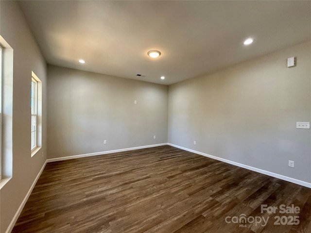 empty room featuring visible vents, baseboards, recessed lighting, and dark wood finished floors