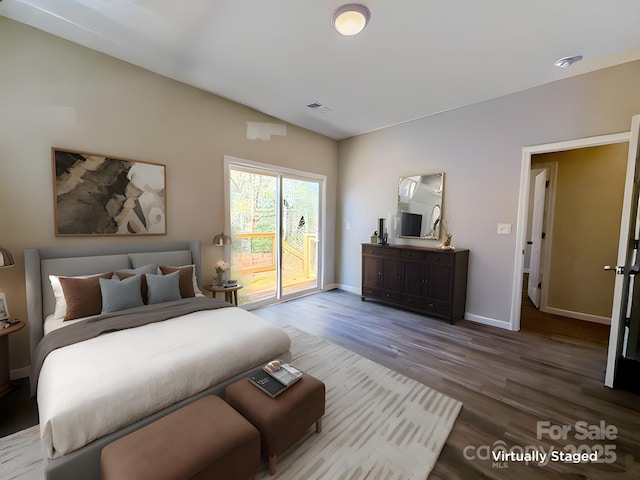 bedroom with visible vents, baseboards, access to outside, and wood finished floors
