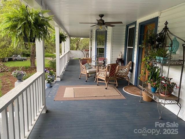 wooden deck featuring a porch and a ceiling fan