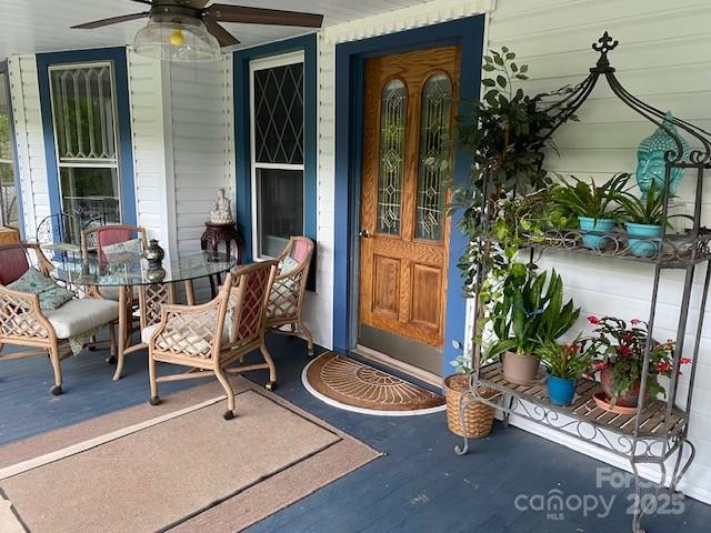 entrance to property with outdoor dining area and ceiling fan