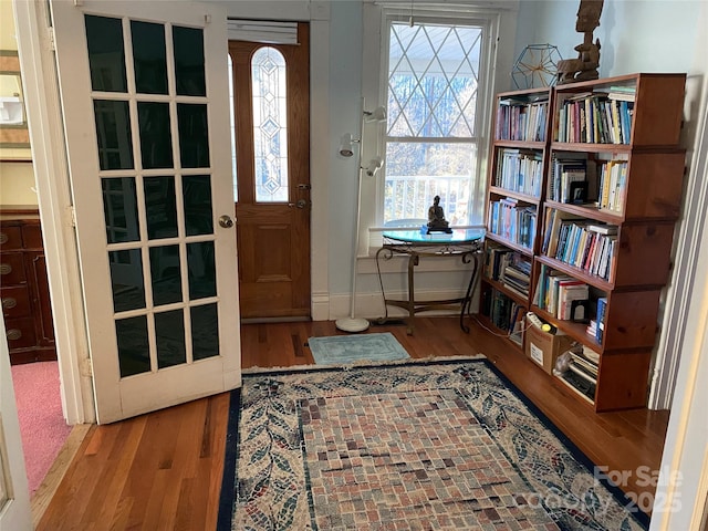 foyer with plenty of natural light, baseboards, and wood finished floors