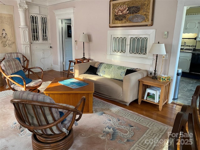 living room featuring decorative columns and wood finished floors
