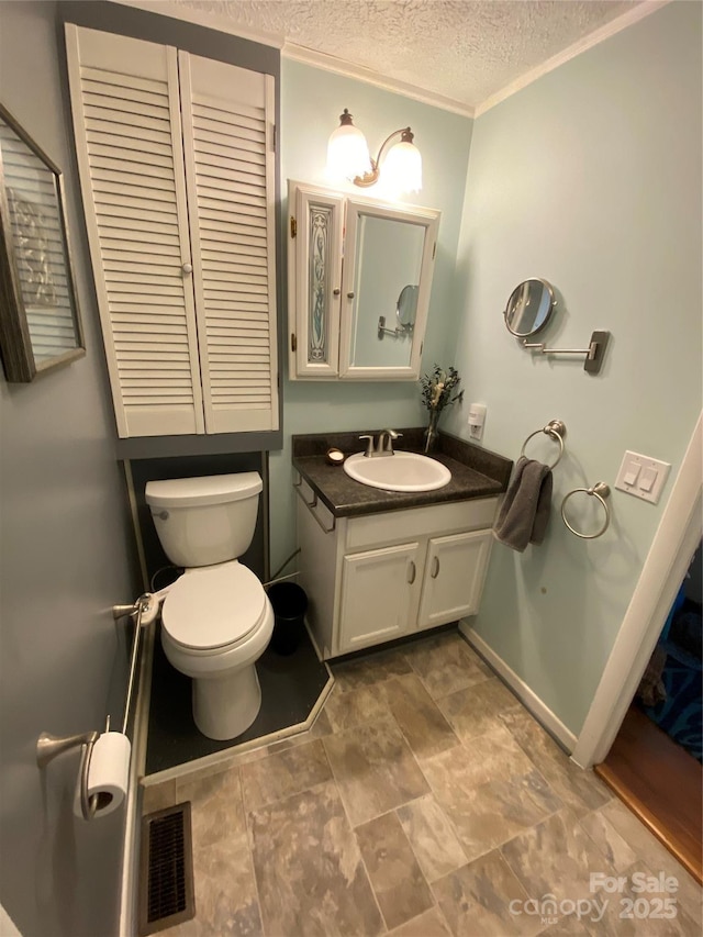 bathroom with visible vents, baseboards, toilet, a textured ceiling, and vanity
