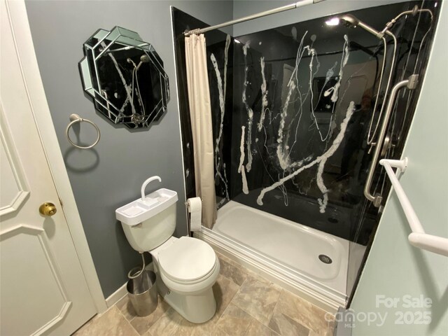 bathroom with toilet and a marble finish shower