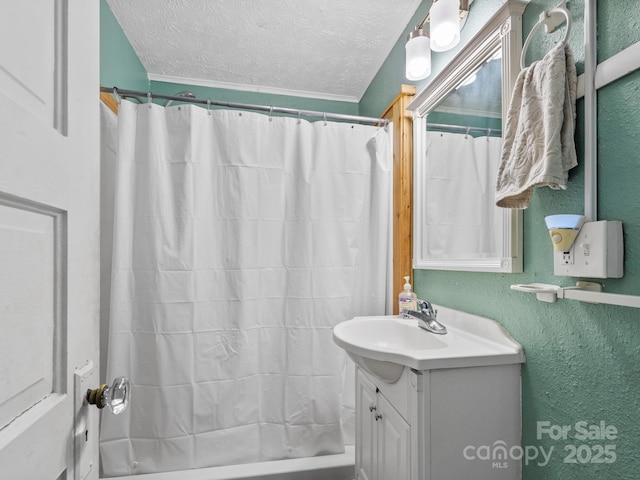 bathroom with shower / tub combo with curtain, vanity, a textured wall, and a textured ceiling