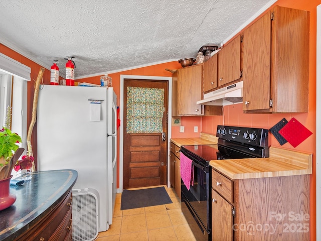 kitchen featuring freestanding refrigerator, light tile patterned floors, a textured ceiling, under cabinet range hood, and black range with electric stovetop