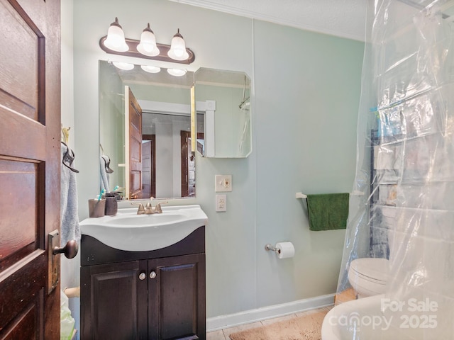 bathroom featuring tile patterned flooring, vanity, baseboards, and toilet