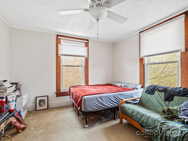 bedroom with ornamental molding, multiple windows, carpet flooring, and a textured ceiling