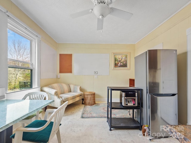 interior space with a textured ceiling and a ceiling fan