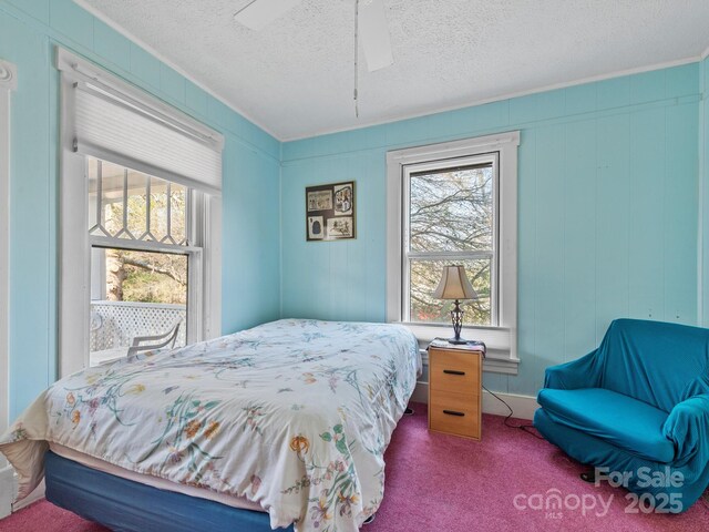 bedroom featuring carpet flooring, a textured ceiling, and a ceiling fan