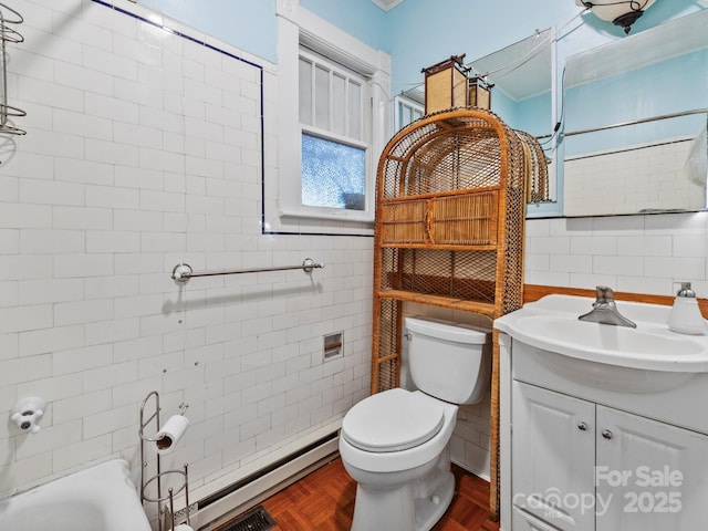bathroom with a baseboard radiator, vanity, tile walls, and toilet