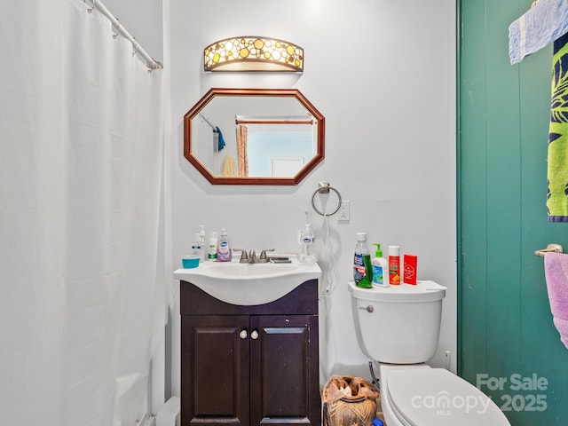 bathroom with toilet, vanity, and a shower with shower curtain