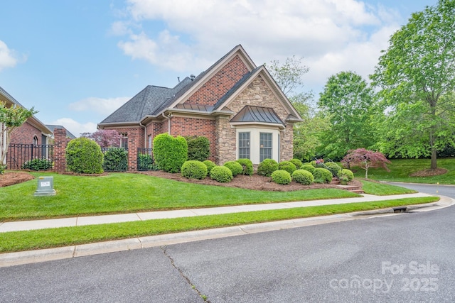 104 Hallmark Xing, Rock Hill, SC 29732 - view of front facade with a standing seam roof, fence, brick siding, metal roof, and a front lawn