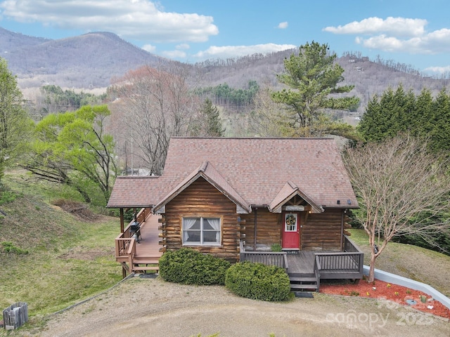 log-style house with a deck with mountain view and log siding