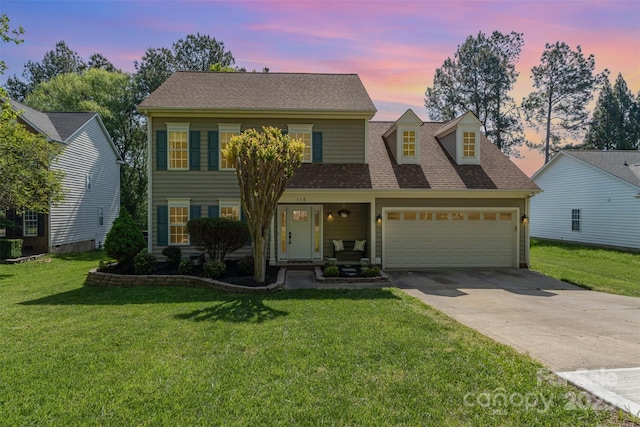 view of front facade featuring concrete driveway, a yard, a shingled roof, and a garage