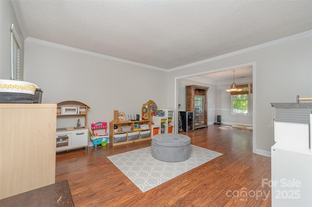 game room with a chandelier, wood finished floors, a textured ceiling, and ornamental molding
