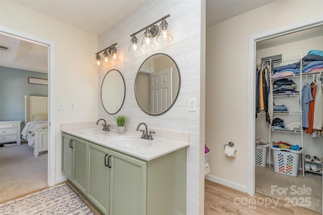 full bathroom featuring a walk in closet, visible vents, a sink, and double vanity