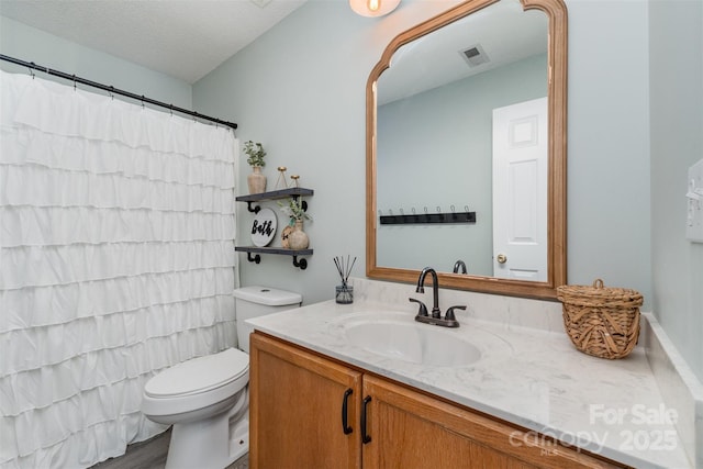bathroom featuring curtained shower, visible vents, toilet, and vanity