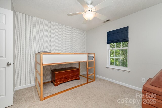 bedroom with visible vents, wallpapered walls, baseboards, and an accent wall