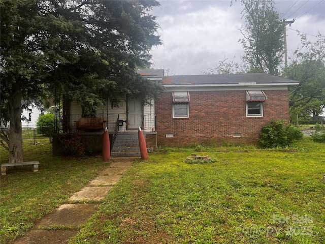 exterior space with crawl space, brick siding, and a lawn
