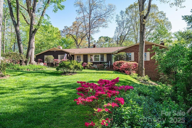 single story home featuring a chimney and a front lawn