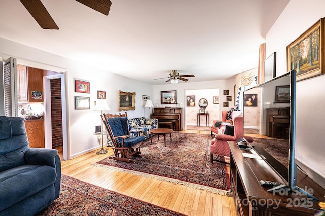 living area with wood-type flooring, baseboards, and ceiling fan