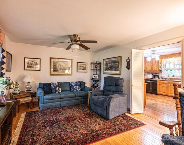 living room featuring light wood-style floors and a ceiling fan