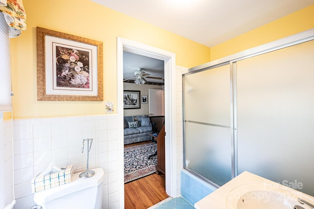bathroom with an enclosed shower, ceiling fan, toilet, and tile walls