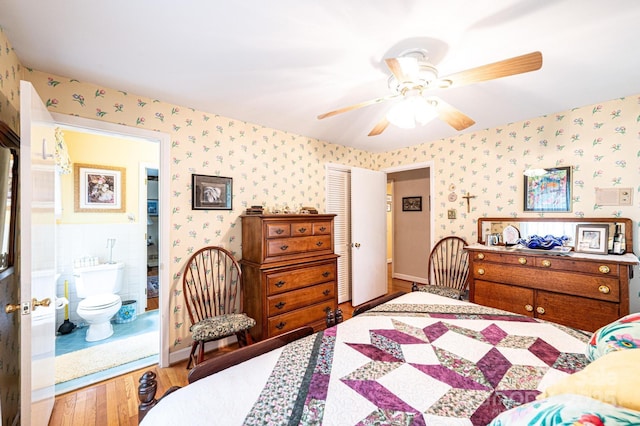 bedroom featuring wallpapered walls, ceiling fan, wood finished floors, and a closet