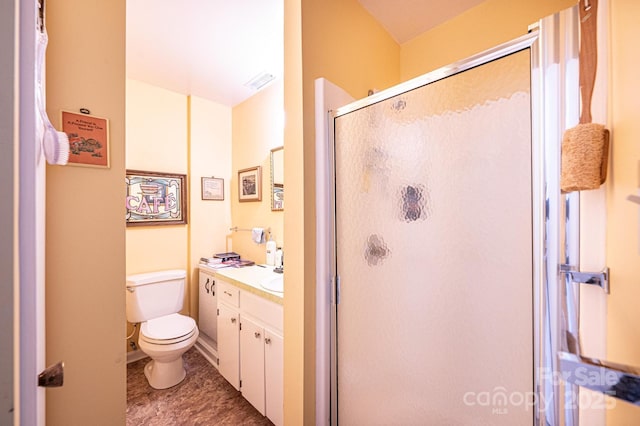 bathroom featuring vanity, visible vents, toilet, and a shower stall