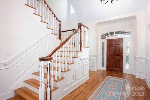 entryway featuring stairs, a decorative wall, and plenty of natural light