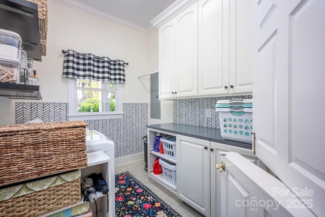 clothes washing area featuring cabinet space, light tile patterned floors, and ornamental molding