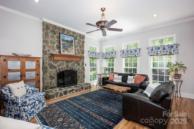 living room with recessed lighting, a ceiling fan, a stone fireplace, ornamental molding, and wood finished floors