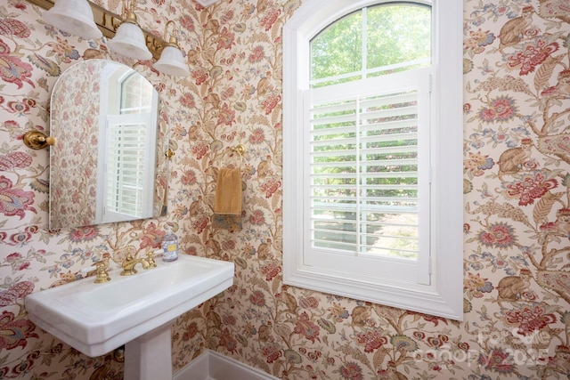 bathroom with a sink and wallpapered walls