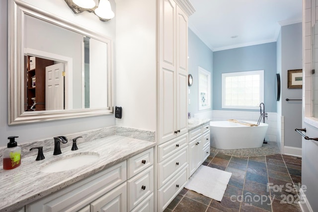 bathroom with stone tile floors, vanity, crown molding, and a soaking tub