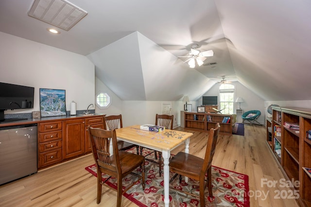 dining room featuring visible vents, ceiling fan, lofted ceiling, and light wood-style floors