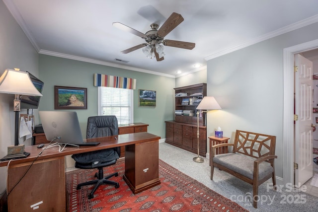 carpeted office with ornamental molding, a ceiling fan, visible vents, and baseboards