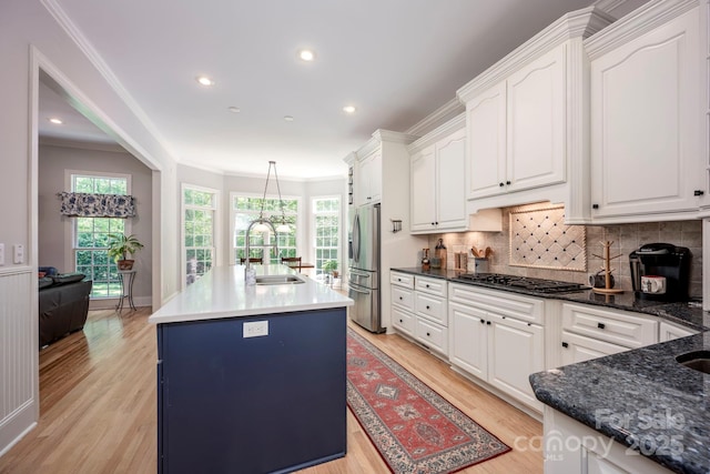 kitchen featuring white cabinets, light wood-type flooring, appliances with stainless steel finishes, and a sink