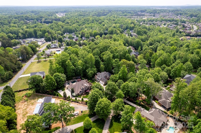 birds eye view of property featuring a residential view and a wooded view