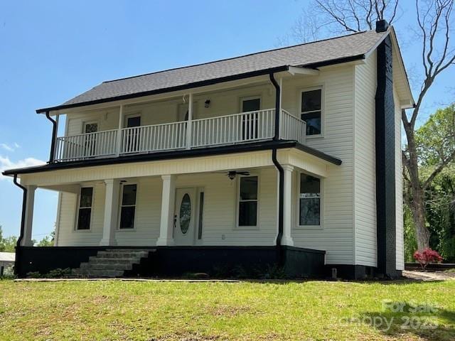 view of front of home with a chimney, a front lawn, covered porch, and a balcony
