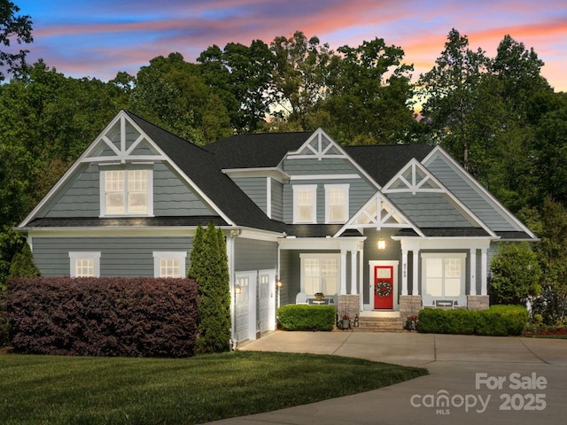 view of front of property featuring concrete driveway, a lawn, and a garage