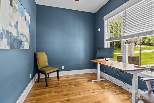 home office with baseboards and wood finished floors