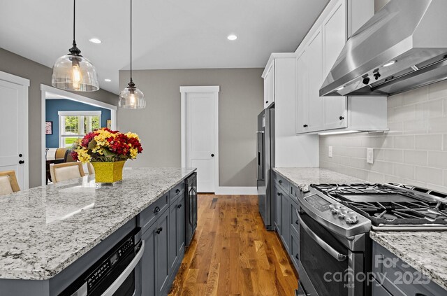 kitchen featuring white cabinets, appliances with stainless steel finishes, wall chimney exhaust hood, recessed lighting, and light wood-type flooring