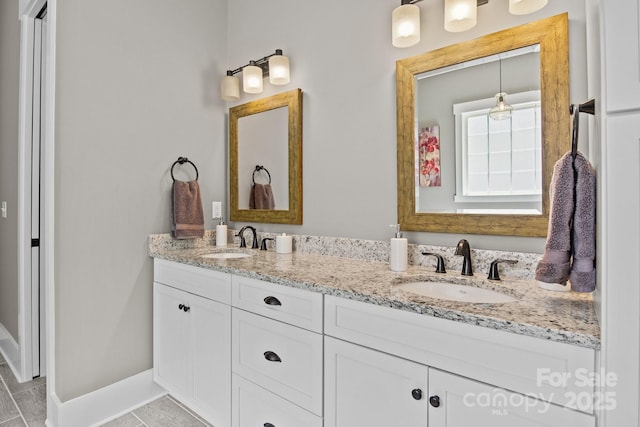 bathroom featuring a sink, baseboards, and double vanity