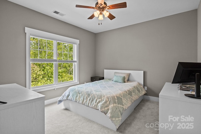 bedroom with baseboards, ceiling fan, light colored carpet, and visible vents