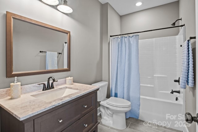 bathroom with vanity, wood finished floors, shower / bath combination with curtain, and toilet