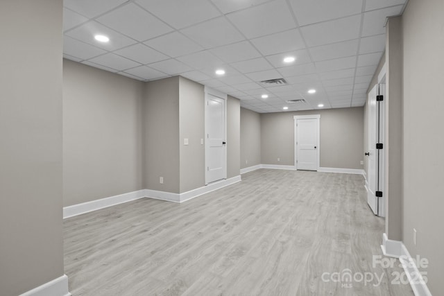 finished below grade area featuring baseboards, wood finished floors, and visible vents