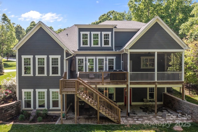 back of house with stairs, a shingled roof, a deck, and a patio