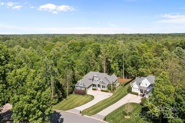 bird's eye view with a wooded view