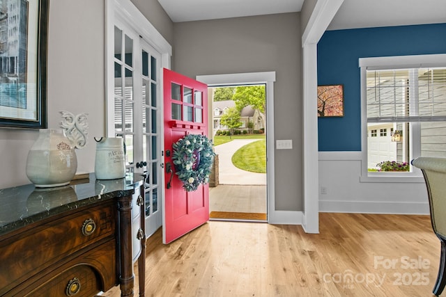 foyer featuring baseboards, french doors, and wood finished floors